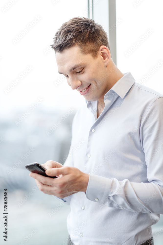 smiling businessman with smartphone in office smiling businessman with smartphone in office