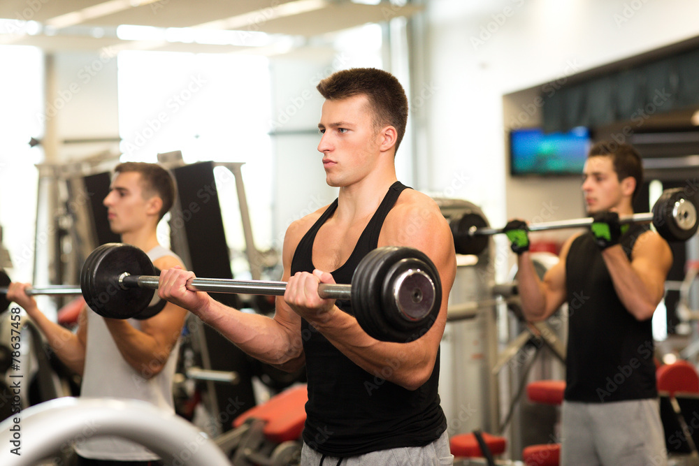 group of men with barbells in gym group of men with barbells in gym