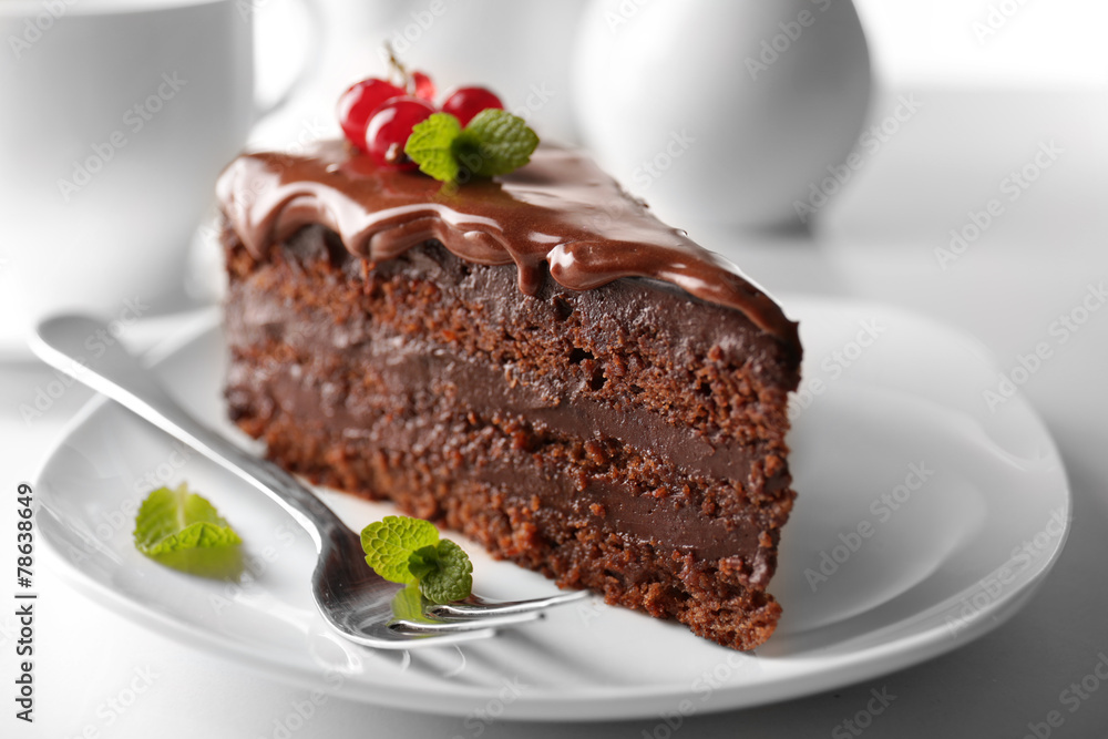 Delicious chocolate cake on plate on table on light background Delicious chocolate cake on plate on table on light background