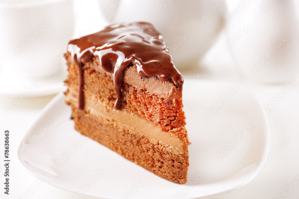 Delicious chocolate cake on plate on table on light background Delicious chocolate cake on plate on table on light background