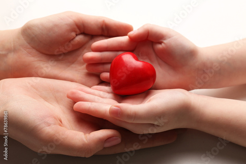 Fototapeta Naklejka Na Ścianę i Meble -  Heart in child and mother hands isolated on white