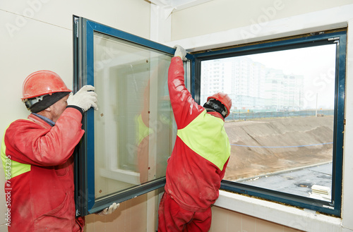 two workers installing window