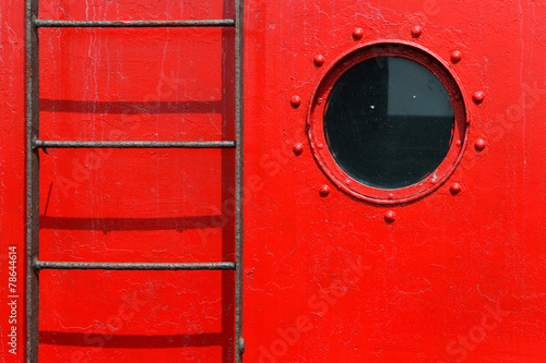 porthole and ladder on a  red ship