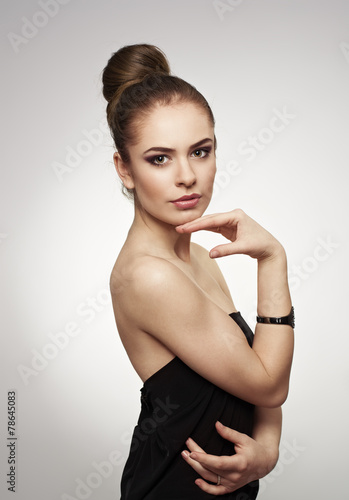 Glamour fashion model with stylish hairdo posing in studio