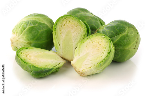  cut brussel sprouts and some whole ones on a white background
