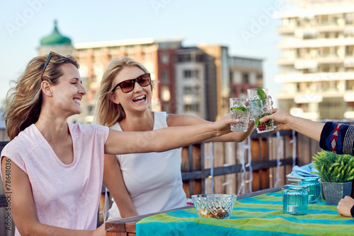 cheerful friends drinking cocktails