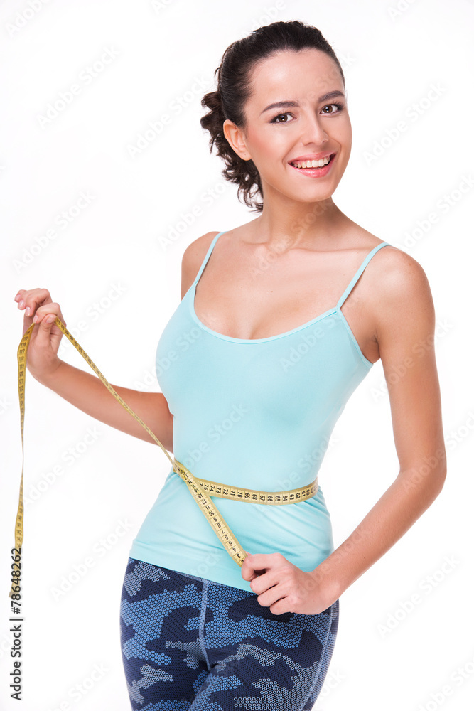 Fit woman measuring her waist