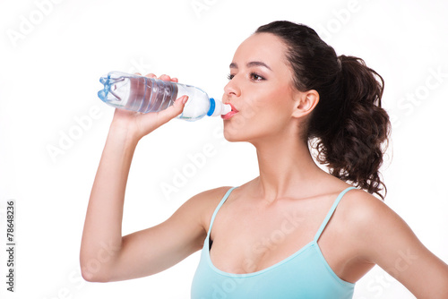 Young sporty woman drinking water