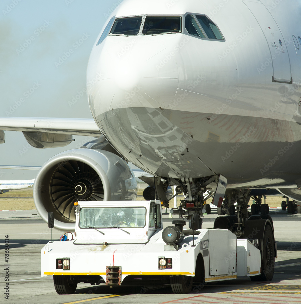 Tug moving a passenger jet Tug moving a passenger jet