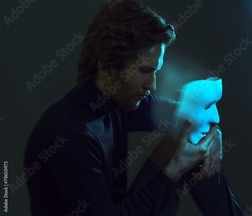 Fotografie arty portrait of a man with mask, holding and looking at venetia
