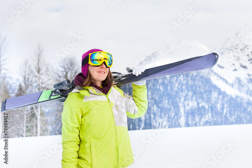 Beautiful woman in mask standing and holding ski