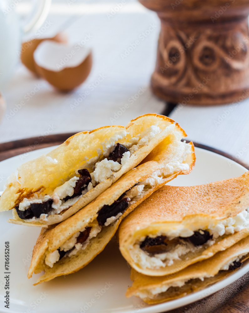 thin pancakes stuffed with cheese, prunes and sour cream, milk