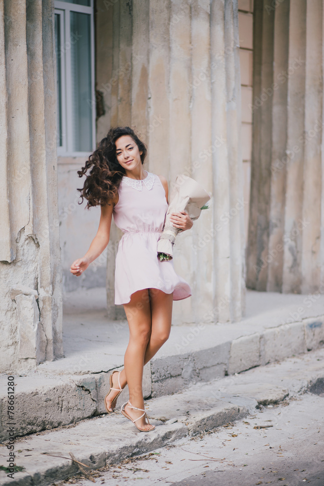 Beautiful girl with a bouquet of peonies posing near old columns Beautiful girl with a bouquet of peonies posing near old columns