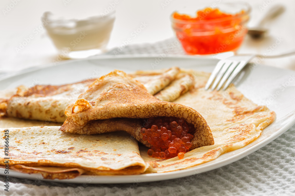plate of pancakes, red caviar, sour cream on a wooden table plate of pancakes, red caviar, sour cream on a wooden table
