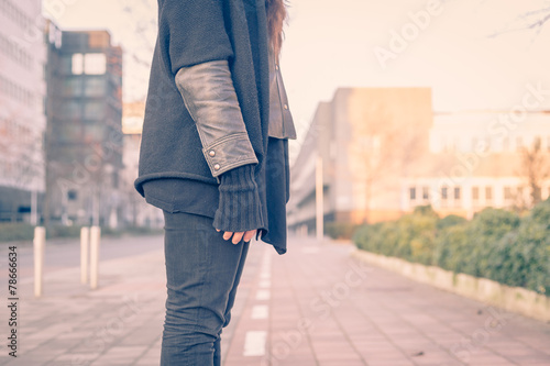 Detail of a young woman posing in the city streets