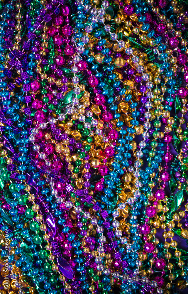 A background of  brightly colored Mardi-Gras beads