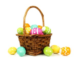 Easter basket filled with colorful eggs on a white background