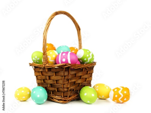 Easter basket filled with colorful eggs on a white background