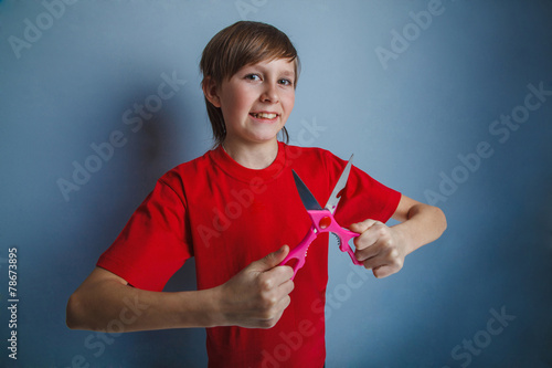 Boy, teenager, twelve years in the red shirt is holding pair of