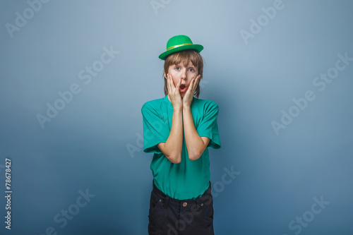 European appearance teenager boy in T-shirt with green hat put h