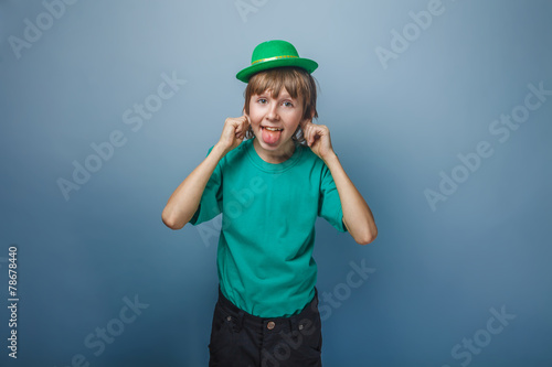 European appearance teenager boy in T-shirt with green hat stret