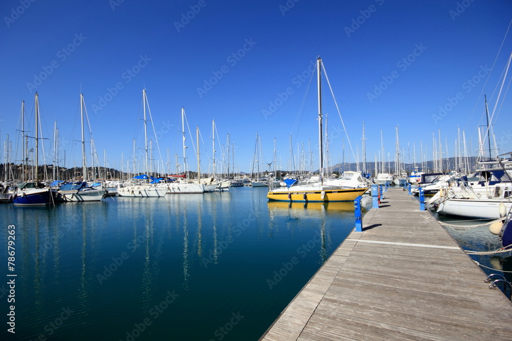 Yachts and sail boats reflected in a Marina harbour