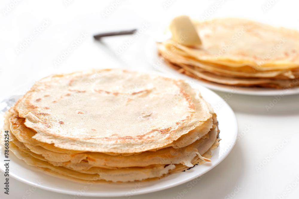 Many pancakes with butter on white background Many pancakes with butter on white background