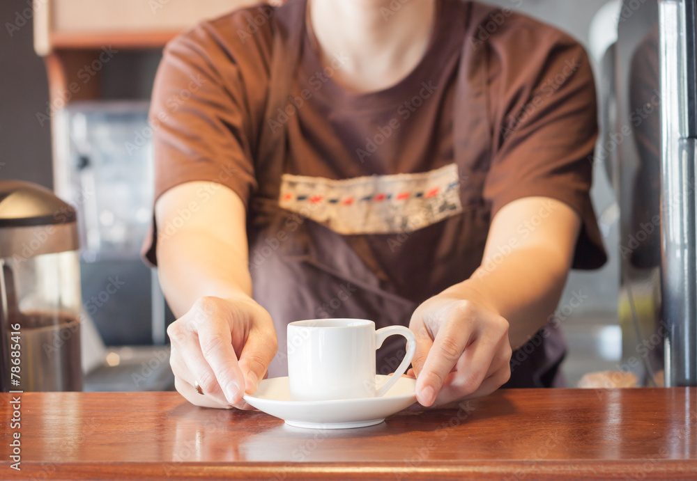 Barista offering mini white cup of coffee Barista offering mini white cup of coffee