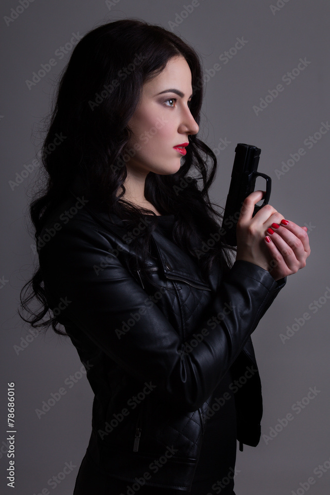 portrait of sexy woman in black with gun over grey portrait of sexy woman in black with gun over grey