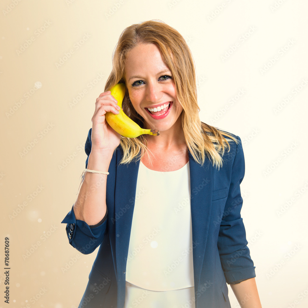 Blonde girl with banana as phone over white background Blonde girl with banana as phone over white background