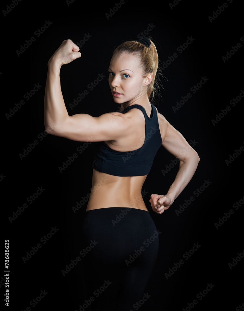 Athletic young woman showing muscles of the back - Stock Image
