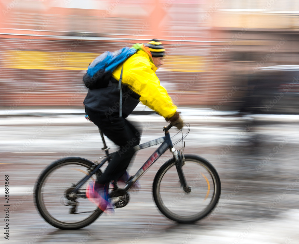 Fototapeta premium Man on bicycle in the city in a winter day