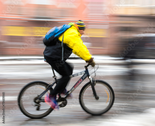 Man on bicycle in the city in a winter day