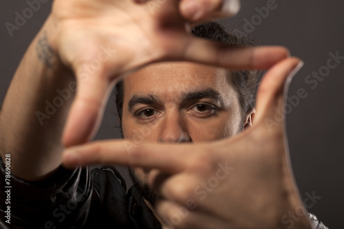 Bilde på lerret young man looking through fingers frame