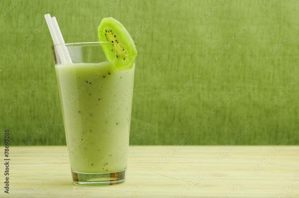 milkshake with kiwi in a glass with straws over green background milkshake with kiwi in a glass with straws over green background