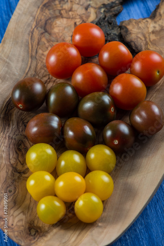 Colorful baby tomatoes on vibrant wooden background
