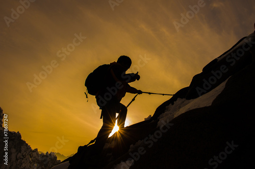 Silhouette of mountaineer and sunset.