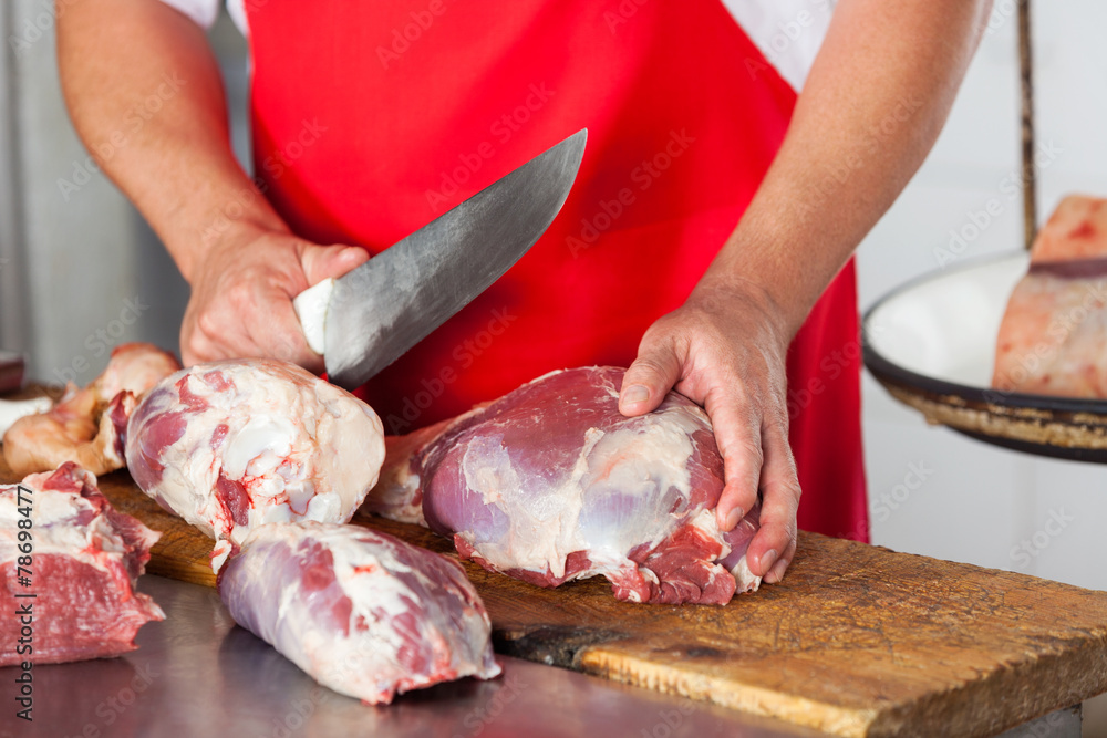 Butcher Cutting Meat With Knife In Butchery