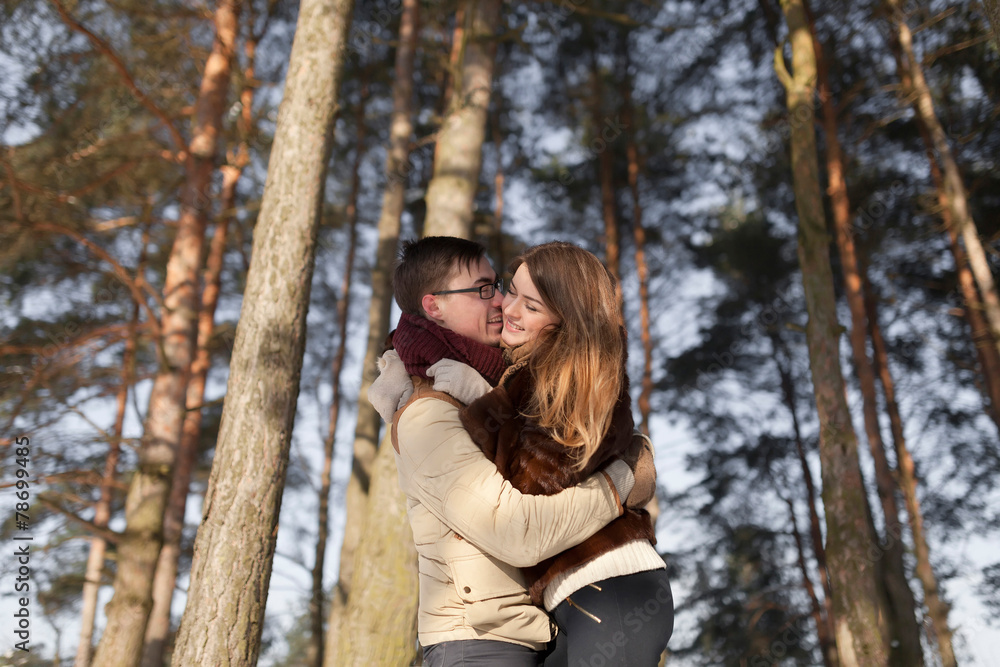 Cheerful couple in a pine forest in winter Cheerful couple in a pine forest in winter