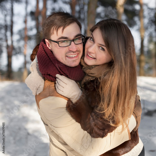Cheerful couple in a pine forest in winter