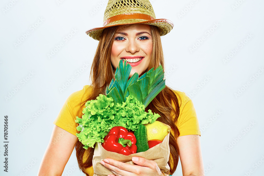 smiling woman holding paper bag with green vegan food