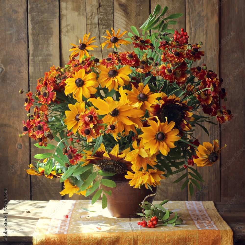 Fototapeta premium букет из красных и желтых цветов на фоне досок