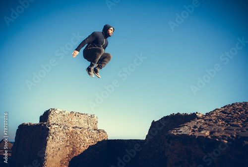 man performs freerunning jump on stones