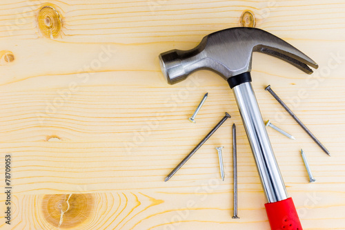 Hammer and nails on a wooden background