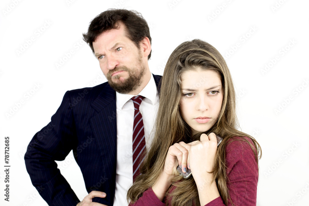 Girl holding tight her cell phone while father is angry Girl holding tight her cell phone while father is angry