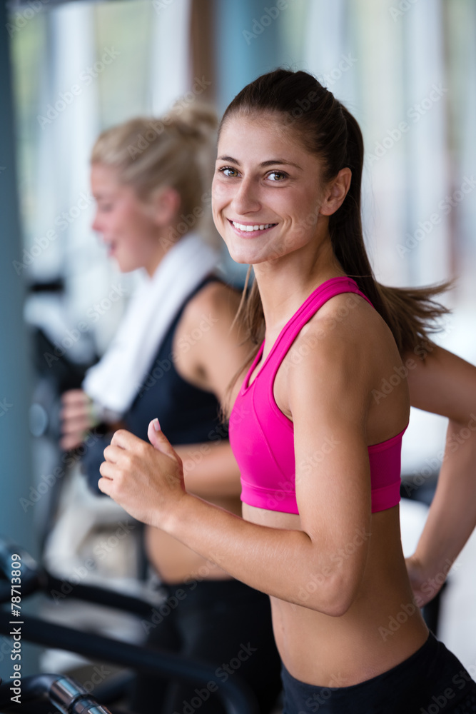 Fototapeta premium friends exercising on a treadmill at the bright modern gym