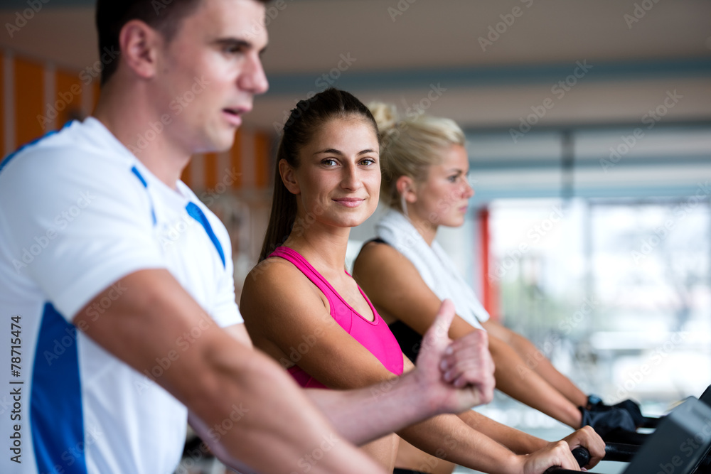 friends exercising on a treadmill at the bright modern gym friends exercising on a treadmill at the bright modern gym