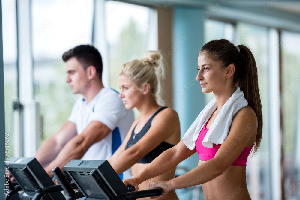 friends exercising on a treadmill at the bright modern gym friends exercising on a treadmill at the bright modern gym