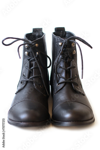 Female pair of black boots with shoelaces tied close up