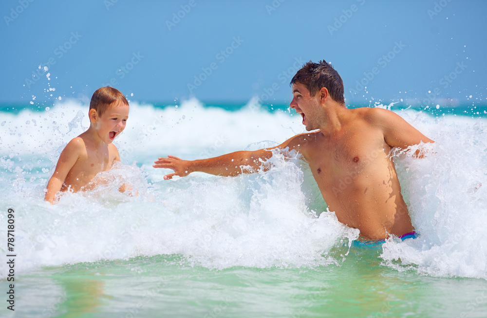happy father and son jumping in waves, summer vacation happy father and son jumping in waves, summer vacation
